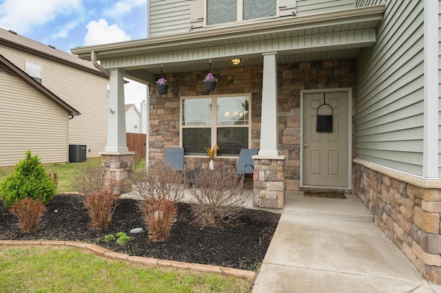 view of exterior entry featuring a porch and cooling unit