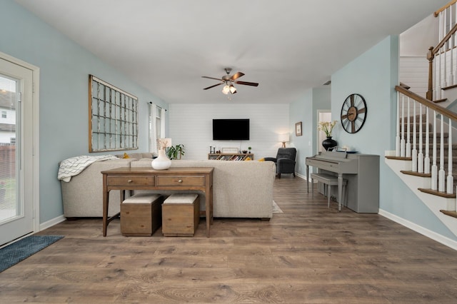 living room featuring ceiling fan and dark wood-type flooring