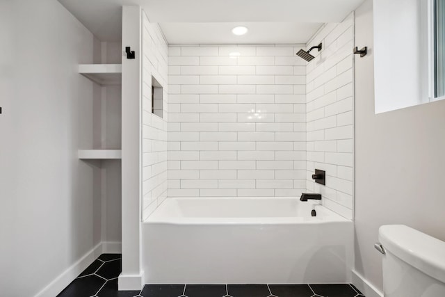 bathroom featuring tile patterned floors, tiled shower / bath combo, and toilet