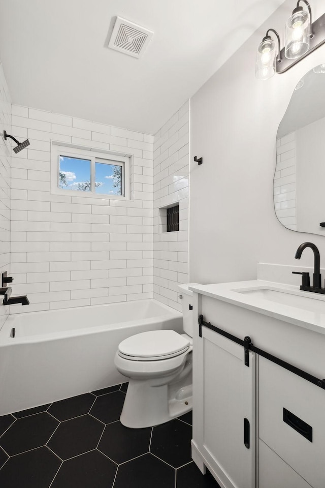 full bathroom with tile patterned flooring, vanity, toilet, and tiled shower / bath combo