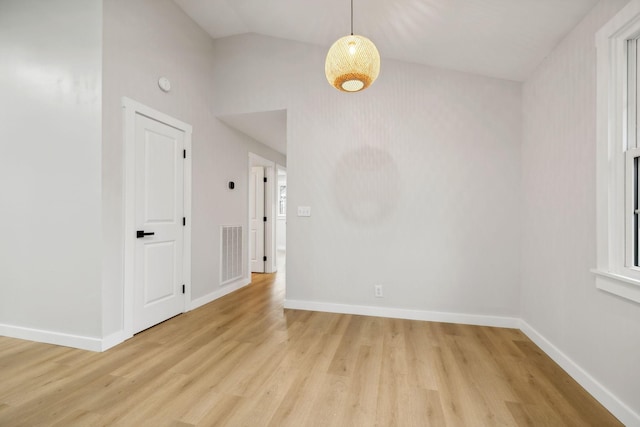 spare room with light hardwood / wood-style flooring and vaulted ceiling