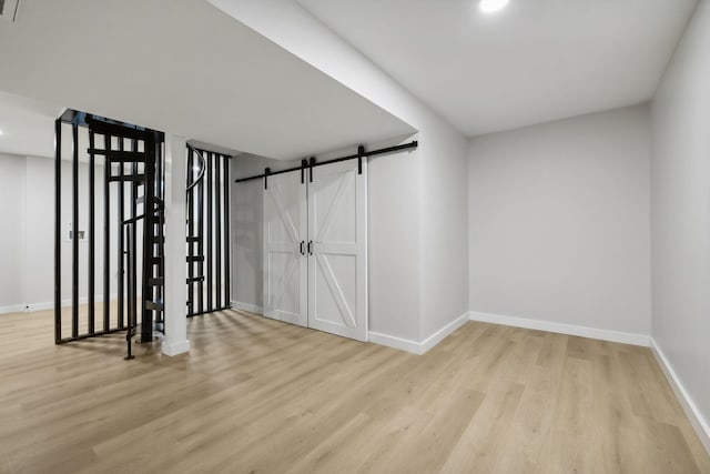 interior space with a barn door and hardwood / wood-style floors