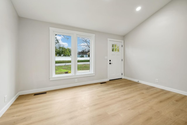 entrance foyer featuring light hardwood / wood-style floors and vaulted ceiling