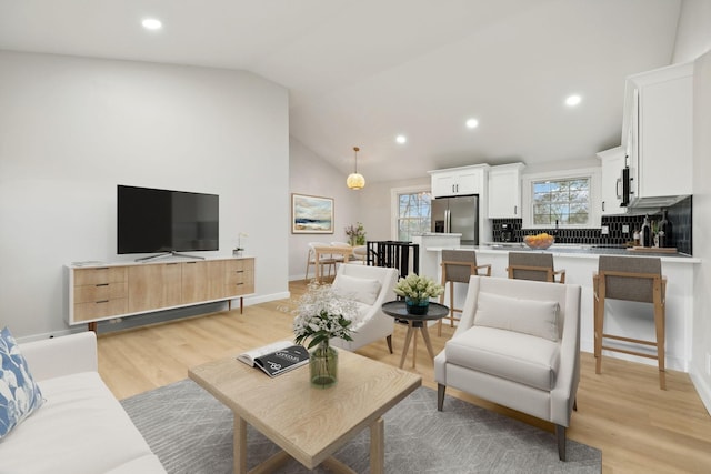 living room featuring light wood-type flooring and lofted ceiling