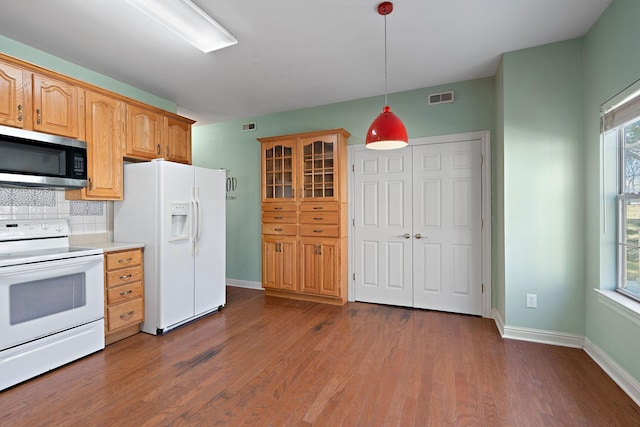 kitchen with hanging light fixtures, tasteful backsplash, dark hardwood / wood-style flooring, and white appliances