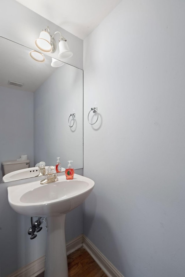 bathroom with hardwood / wood-style flooring, toilet, and sink