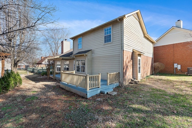 rear view of property with a wooden deck, central AC unit, and a pergola