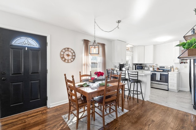 dining room with light hardwood / wood-style flooring and a notable chandelier