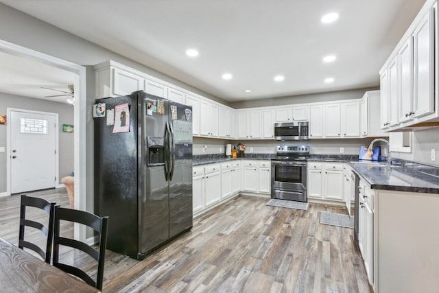 kitchen with white cabinetry, sink, ceiling fan, and stainless steel appliances