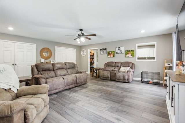 living room featuring ceiling fan and light hardwood / wood-style floors