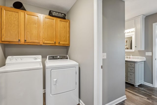 laundry room featuring cabinets, independent washer and dryer, and dark hardwood / wood-style flooring