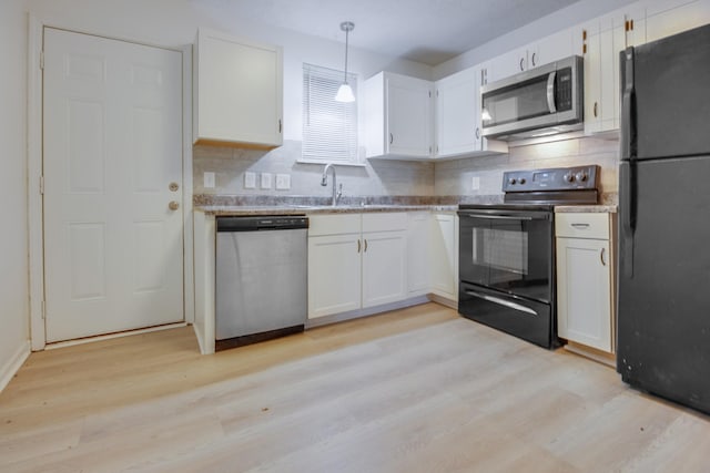 kitchen featuring black appliances, decorative light fixtures, light hardwood / wood-style floors, and white cabinets