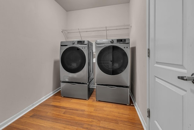 laundry room featuring light wood-type flooring and washer and clothes dryer