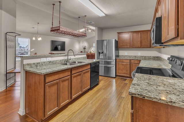 kitchen with pendant lighting, a center island with sink, sink, a notable chandelier, and stainless steel appliances