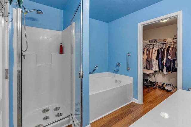 bathroom with hardwood / wood-style floors and shower with separate bathtub