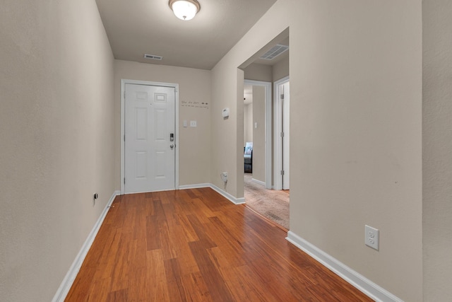 corridor with hardwood / wood-style flooring