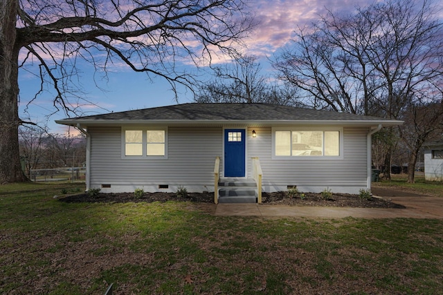 view of front of house with entry steps, crawl space, roof with shingles, and a front yard