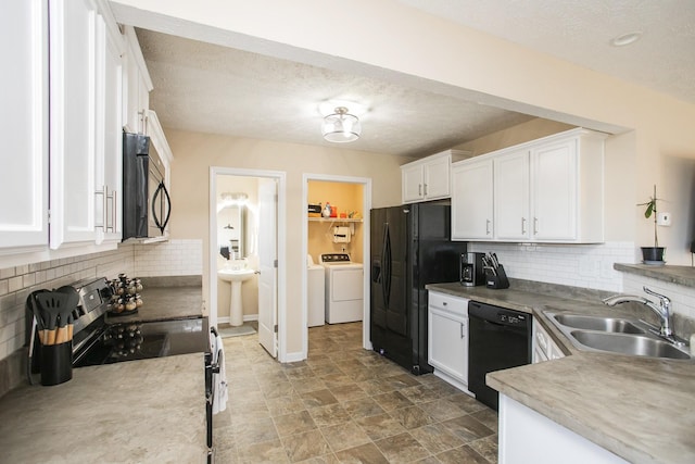 kitchen featuring a textured ceiling, sink, black appliances, separate washer and dryer, and white cabinets