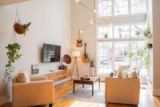 living room with a towering ceiling and light hardwood / wood-style floors