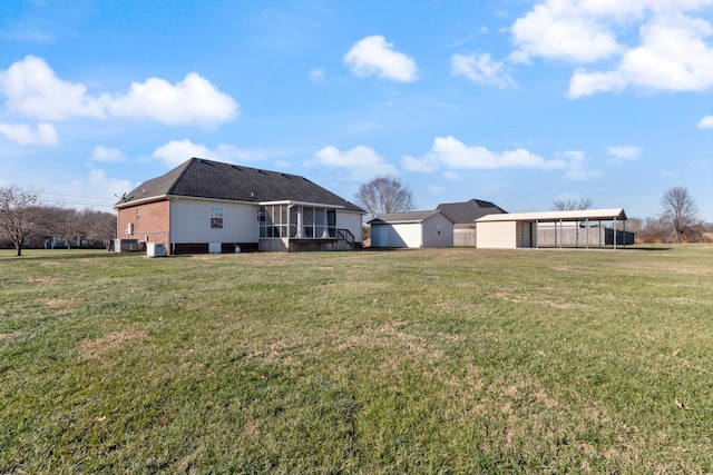 view of yard featuring a sunroom, central AC, and a carport