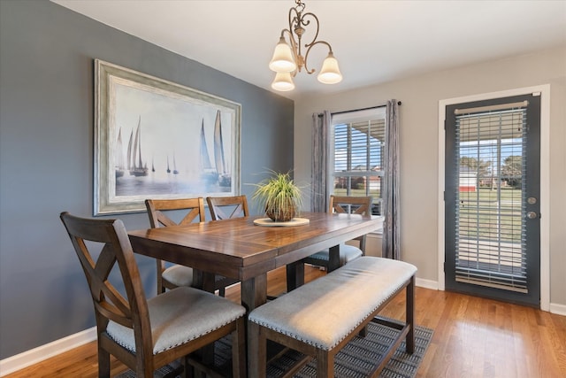 dining space featuring light hardwood / wood-style flooring and a chandelier