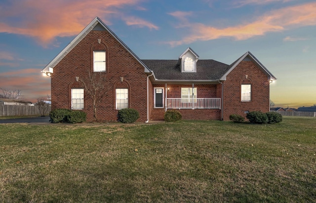 front of property with covered porch and a lawn