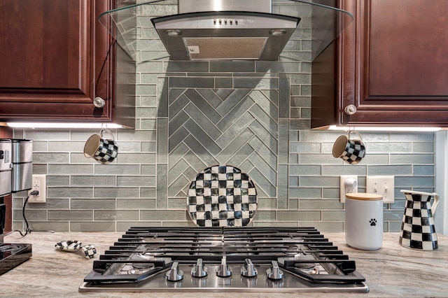 kitchen with backsplash, light stone counters, extractor fan, and stainless steel gas stovetop