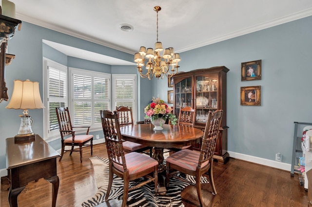 dining space featuring dark wood-type flooring, a chandelier, and ornamental molding