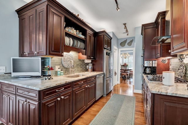 kitchen featuring sink, stainless steel appliances, tasteful backsplash, light hardwood / wood-style flooring, and dark brown cabinets