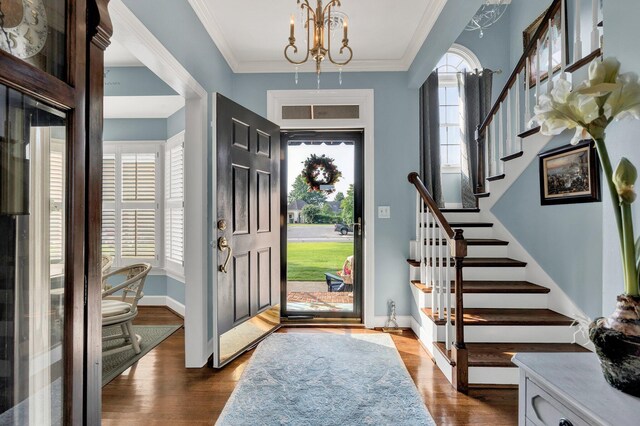 entryway featuring dark hardwood / wood-style flooring, an inviting chandelier, and crown molding