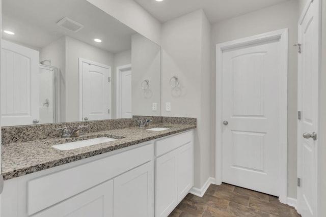 bathroom featuring vanity and an enclosed shower