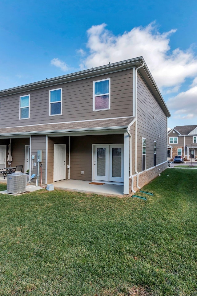 back of property featuring a patio area, a yard, and central AC