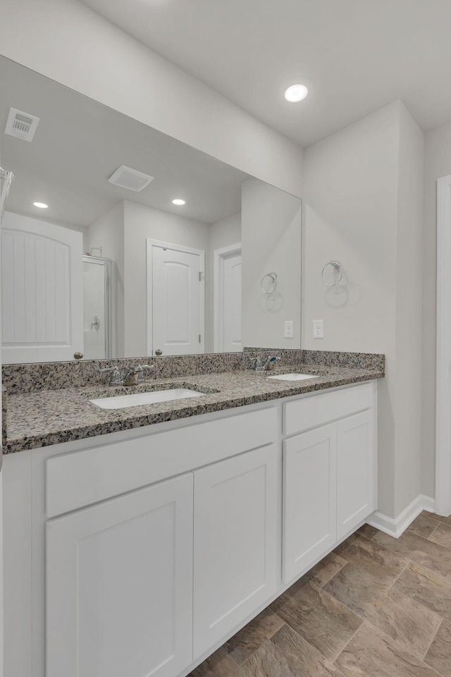 bathroom featuring vanity and a shower with door