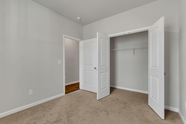 unfurnished bedroom featuring light colored carpet and a closet