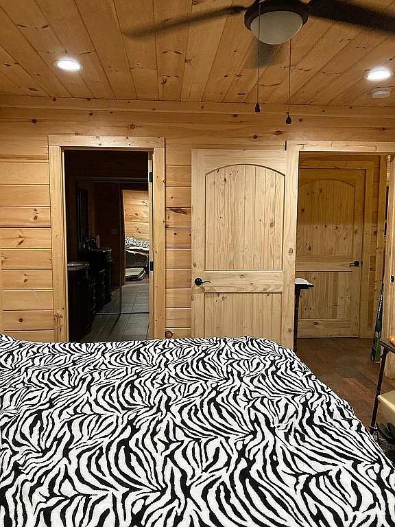 bedroom featuring wooden ceiling and wooden walls