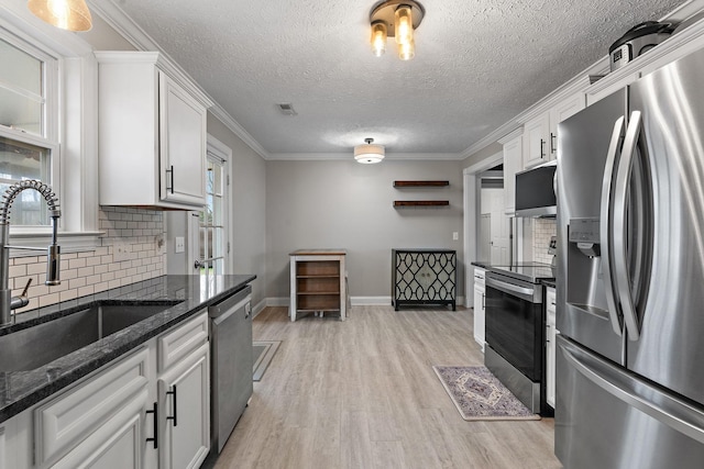 kitchen featuring white cabinetry, sink, ornamental molding, and appliances with stainless steel finishes