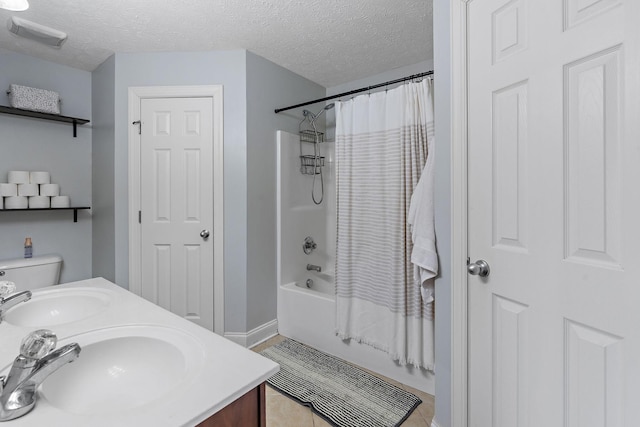 bathroom with shower / tub combo with curtain, vanity, and a textured ceiling