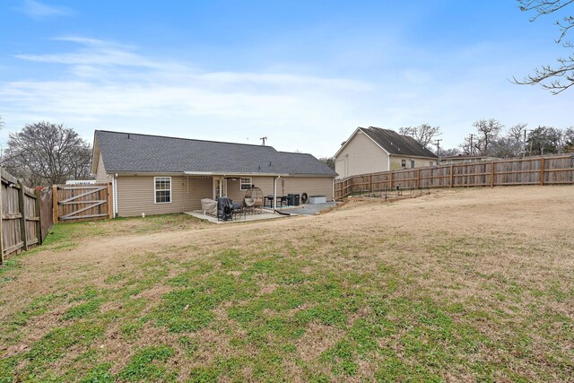 back of house with a patio area and a lawn