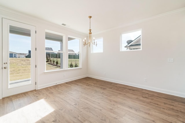 unfurnished dining area with crown molding, light hardwood / wood-style flooring, and an inviting chandelier