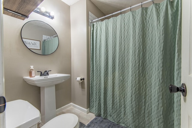 bathroom with tile patterned flooring, sink, toilet, and walk in shower