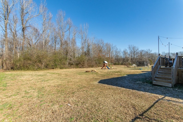 view of yard with a trampoline and a playground