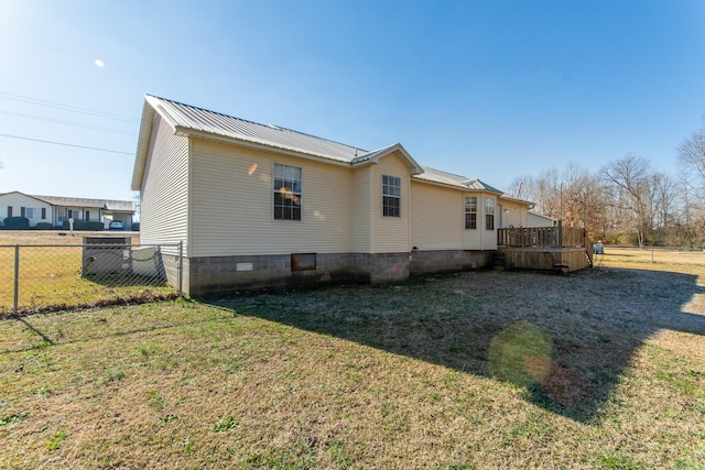 view of side of property featuring a wooden deck and a lawn