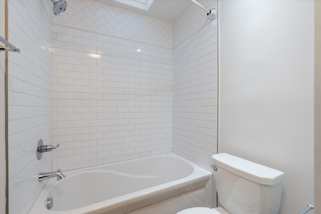 bathroom with toilet and tiled shower / bath