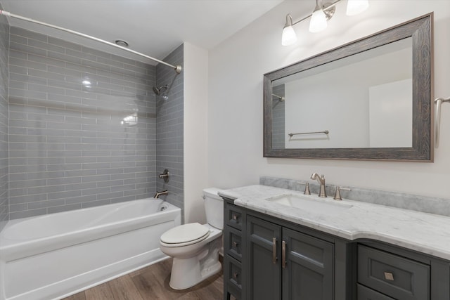 full bathroom featuring hardwood / wood-style floors, vanity, toilet, and tiled shower / bath combo