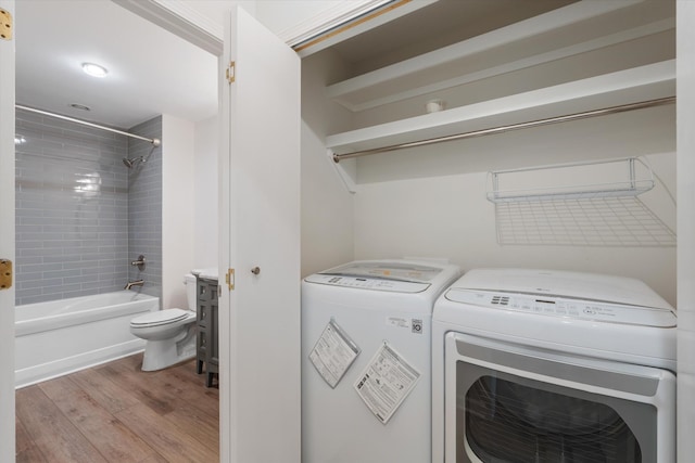 laundry room featuring separate washer and dryer and light hardwood / wood-style floors