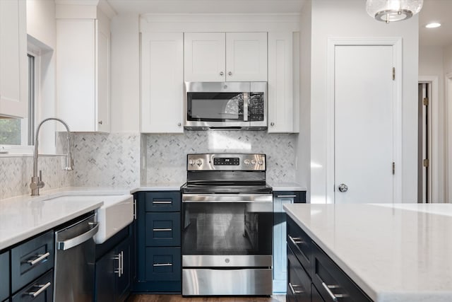 kitchen featuring white cabinets, stainless steel appliances, and blue cabinets