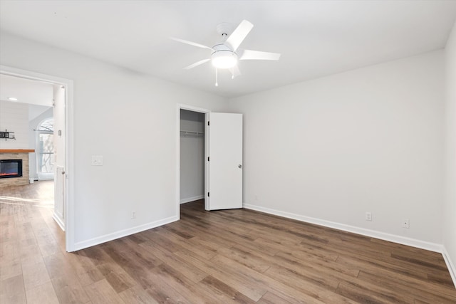 unfurnished bedroom with ceiling fan, a closet, and hardwood / wood-style floors