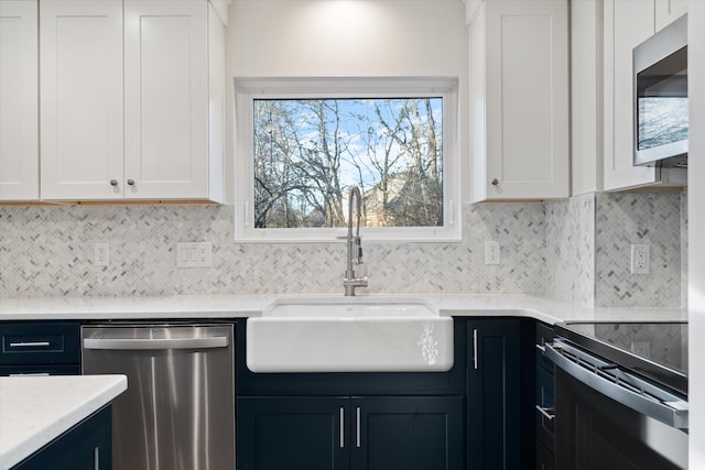 kitchen featuring white cabinets, backsplash, stainless steel appliances, and sink