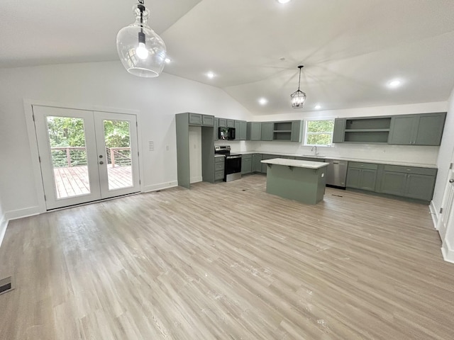 kitchen featuring french doors, stainless steel appliances, decorative light fixtures, a kitchen island, and lofted ceiling