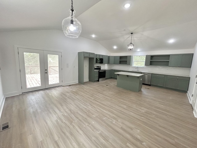 kitchen featuring a center island, sink, hanging light fixtures, stainless steel appliances, and light hardwood / wood-style flooring